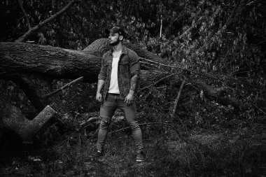 Siyah ve beyaz fotoğraf yakışıklı genç erkek adam açık havada yaz ormanda poz