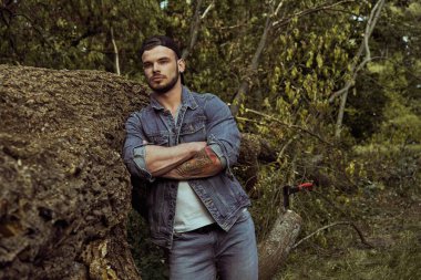 Yakışıklı genç erkek adam açık havada yaz ormanda poz