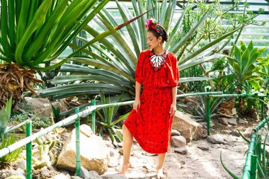 Zarif kırmızı elbise ve çiçek headdress muhteşem genç kadın 