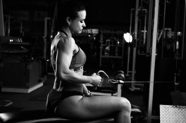 Siyah ve beyaz fotoğraf genç esmer kaslı kadın spor salonunda egzersiz