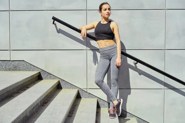 merdivenlerin üzerinde duran sportif genç esmer kadın            