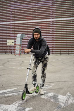 Tekme scooter poz ile şık genç sakallı adam