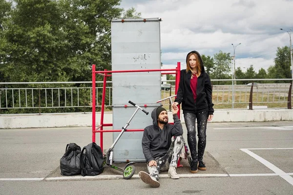 Pasangan Muda Bergaya Dengan Scooters Kick Latar Belakang Perkotaan — Stok Foto