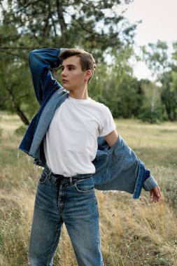 Yakışıklı genç adam açık havada poz rahat denim giysileri 