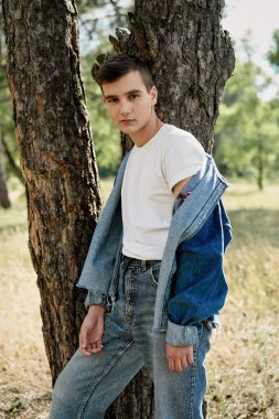 Yakışıklı genç adam açık havada poz rahat denim giysileri 