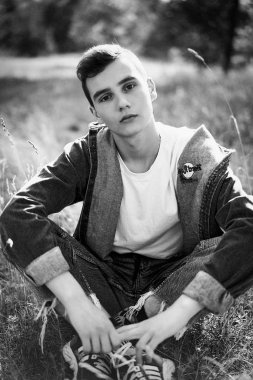 Yakışıklı genç adam açık havada poz rahat denim giysileri 