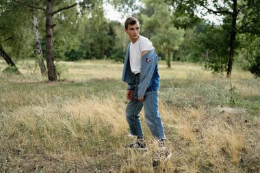 Yakışıklı genç adam açık havada poz rahat denim giysileri 