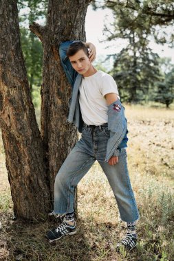 Yakışıklı genç adam açık havada poz rahat denim giysileri 