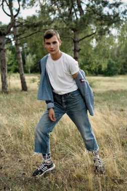 Yakışıklı genç adam açık havada poz rahat denim giysileri 