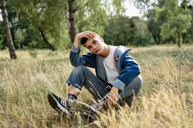 Yakışıklı genç adam açık havada poz rahat denim giysileri 