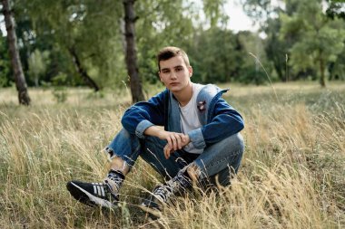 Yakışıklı genç adam açık havada poz rahat denim giysileri 