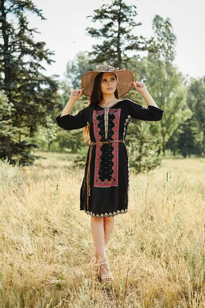 Hasır şapka açık havada güneşli yaz gününde poz içinde güzel genç kadın 