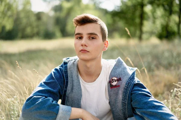 Yakışıklı genç adam açık havada poz rahat denim giysileri 