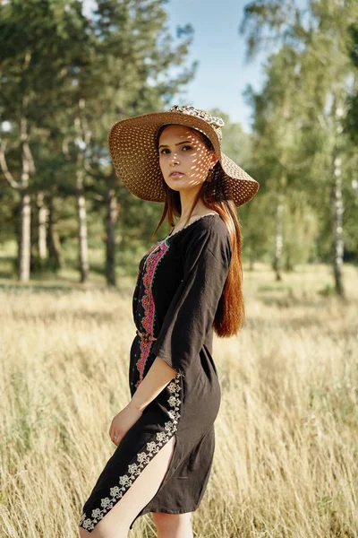 Hasır şapka açık havada güneşli yaz gününde poz içinde güzel genç kadın 