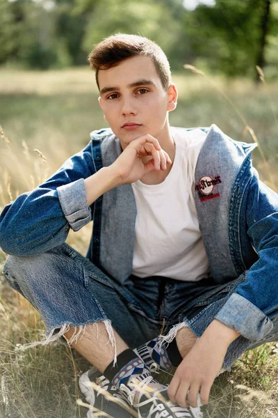 Yakışıklı genç adam açık havada poz rahat denim giysileri 