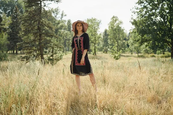 Hasır şapka açık havada güneşli yaz gününde poz içinde güzel genç kadın 