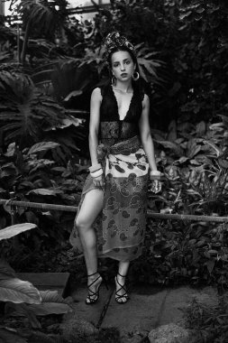 çeşitli bilezik açık havada poz ile zarif headdress içinde çekici genç kadın siyah beyaz fotoğraf 