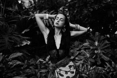 çeşitli bilezik açık havada poz ile zarif headdress içinde çekici genç kadın siyah beyaz fotoğraf 