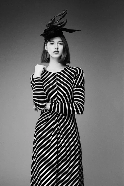 ポーズ スタジオ背景にエレガントなヘッドドレスの豪華な若い女性の黒と白の写真 — ストック写真