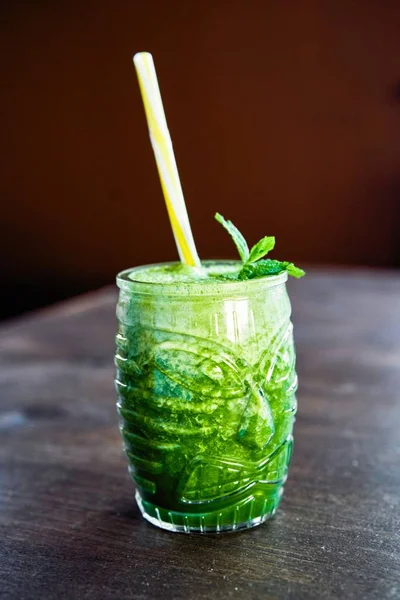 木桌上的绿色酒精鸡尾酒杯 — 图库照片