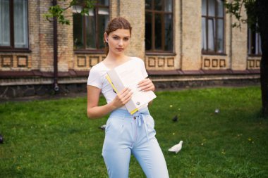  Genç kız öğrenci okul Courtyard ders kitabı ile       