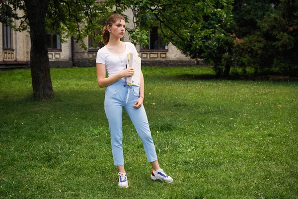  Genç kız öğrenci okul Courtyard ders kitabı ile       