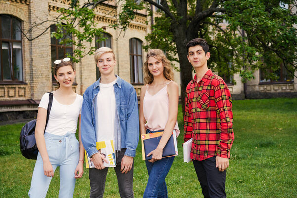 College students    with books at the school courtyard                                  