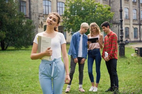  College students    with books at the school courtyard