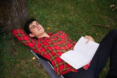  mutlu genç öğrenci çocuk, güneşli bir kitap ile parkta            