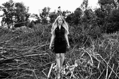  Genç Sarışın kadın doğası üzerine siyah elbise poz