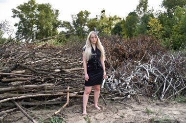  Genç Sarışın kadın doğası üzerine siyah elbise poz