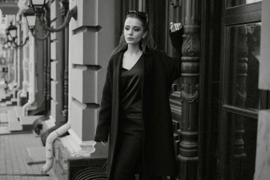 Sokakta poz siyah giysili güzel genç esmer kadın 