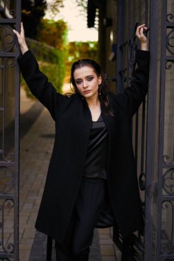 Sokakta poz siyah giysili güzel genç esmer kadın 
