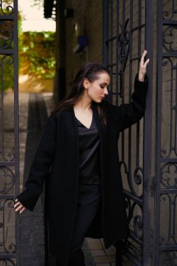 Sokakta poz siyah giysili güzel genç esmer kadın 