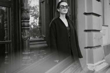 Sokakta poz siyah giysili güzel genç esmer kadın 