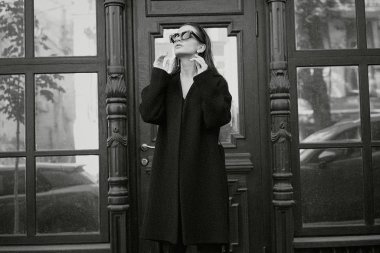 Sokakta poz siyah giysili güzel genç esmer kadın 