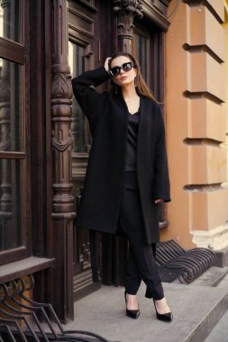 Sokakta poz siyah giysili güzel genç esmer kadın 