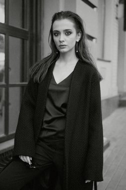 Sokakta poz siyah giysili güzel genç esmer kadın 