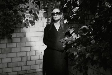 Sokakta poz siyah giysili güzel genç esmer kadın 