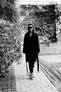 Sokakta poz siyah giysili güzel genç esmer kadın 