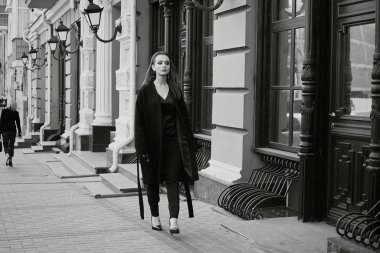 Sokakta poz siyah giysili güzel genç esmer kadın 