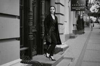 Sokakta poz siyah giysili güzel genç esmer kadın 