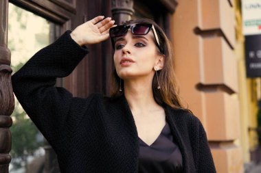 Sokakta poz siyah giysili güzel genç esmer kadın 