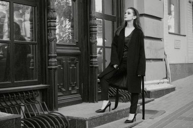 Sokakta poz siyah giysili güzel genç esmer kadın 