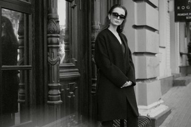 Sokakta poz siyah giysili güzel genç esmer kadın 