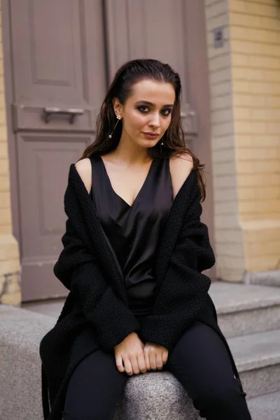 黒服通りのポーズでゴージャスな若いブルネットの女性 — ストック写真