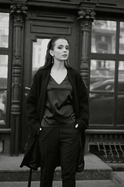 黒い服を着てポーズ豪華な若いブルネットの女性 — ストック写真