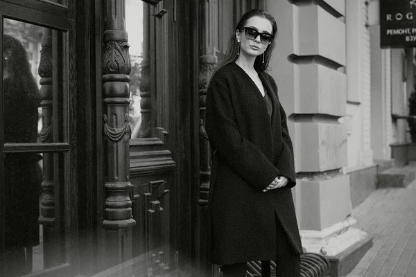 Sokakta poz siyah giysili güzel genç esmer kadın 