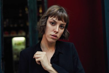 Poz şık siyah giysili genç kısa saçlı kadın              