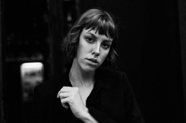 Poz şık siyah giysili genç kısa saçlı kadın              